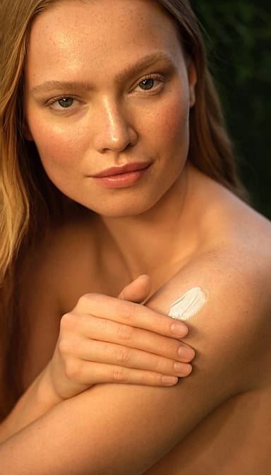 girl sunkissed and applying creme to her body.