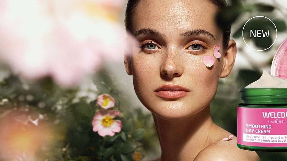 A young woman hiding behind a wild rose bush.